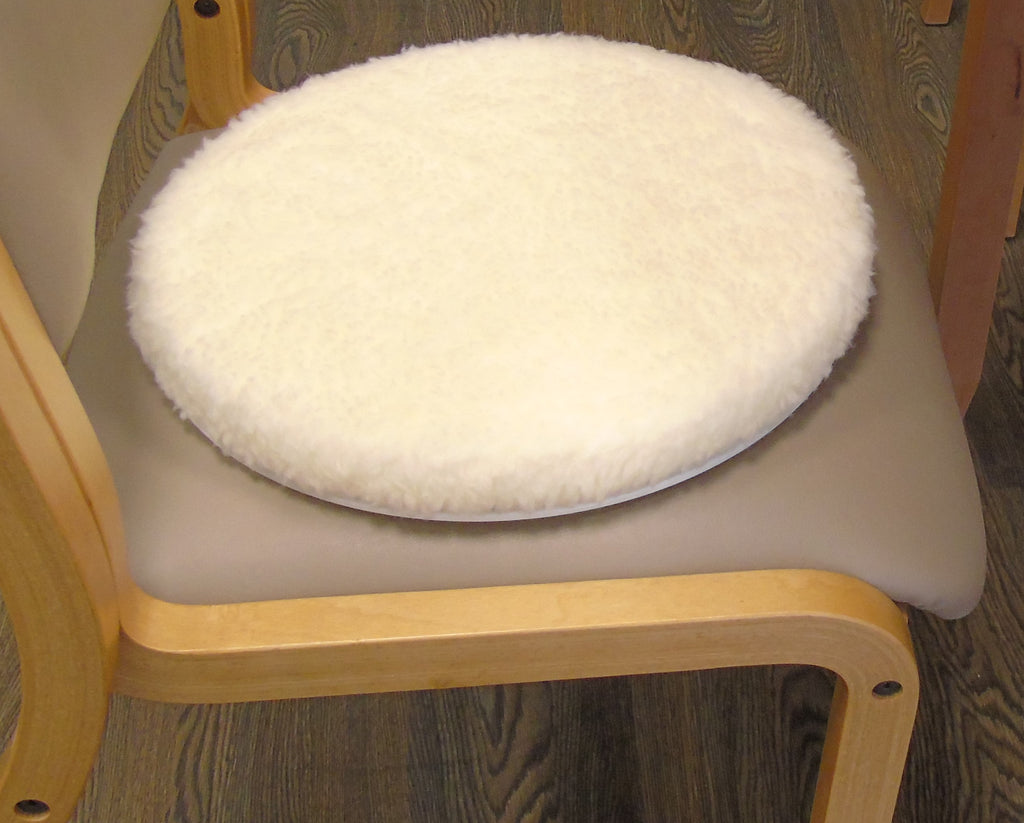 Round white turneasy turning disk cushion on a chair with wooden frame
